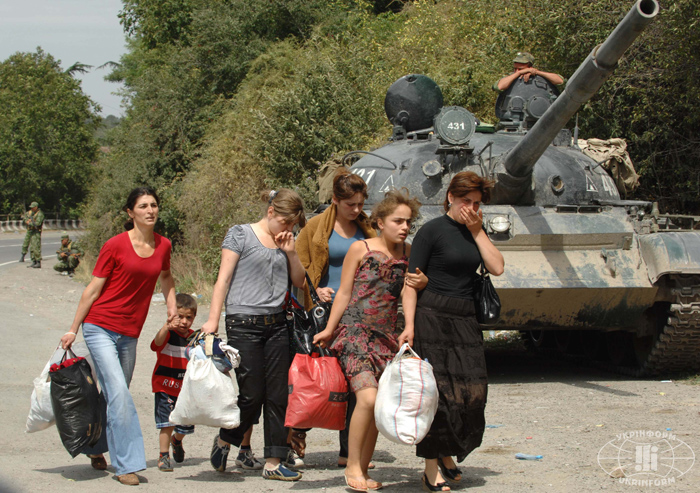 (080817)-- GORI, Aug. 17, 2008 (Xinhua) -- Women and children from Gori walk past a Russian sentry post some 40 kilometers away from Tbilisi, capital of Georgia, Aug. 16, 2008. A platoon of Gori residents fled from their city to Tbilisi. (Xinhua/Dong Aibo) (msq)