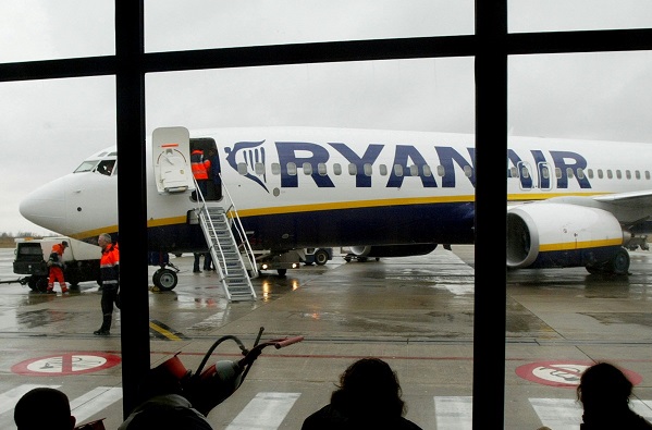 FILE PHOTO - Travellers wait in front of a passenger jet belonging to Irish discount airline Ryanair at Charleroi airport in southern Belgium, February 2, 2004.  REUTERS/Yves Herman/File photo
